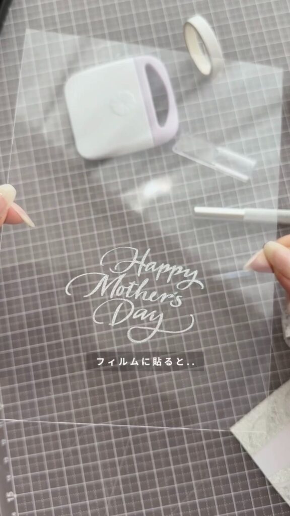 グリッターのカッティングフィルム文字をフレームに転写している様子