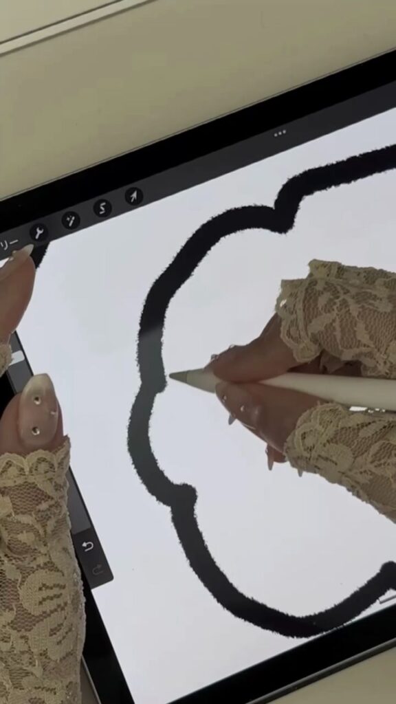 iPadでオリジナルイラストを描いてシールデザインを制作している様子