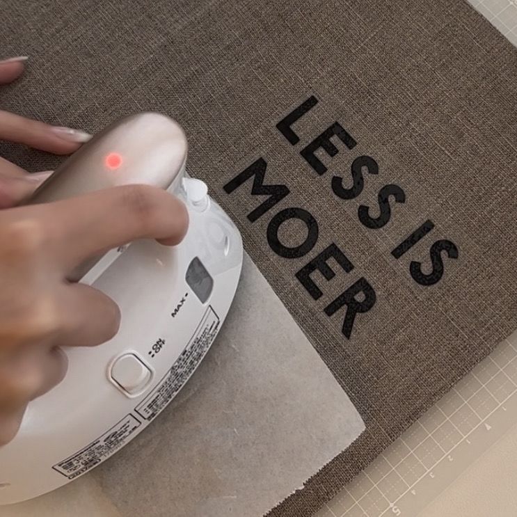 布製ブックカバーの表紙にアイロンシートを圧着している工程