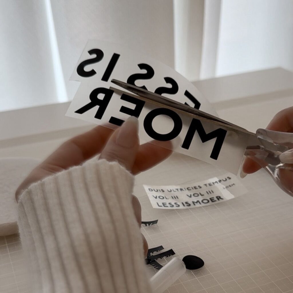 ブックカバー用ロゴシートをカットしている手元