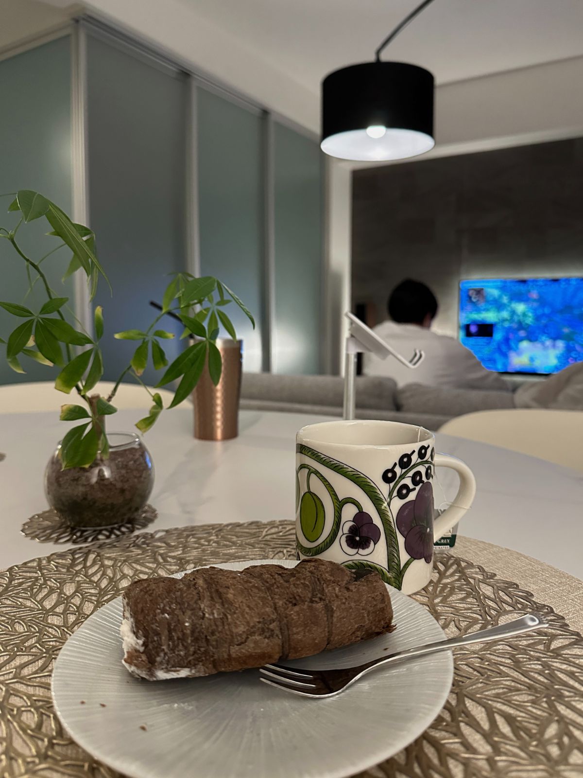 リビングでクロワッサンと紅茶を楽しむ夜のホームカフェ風景