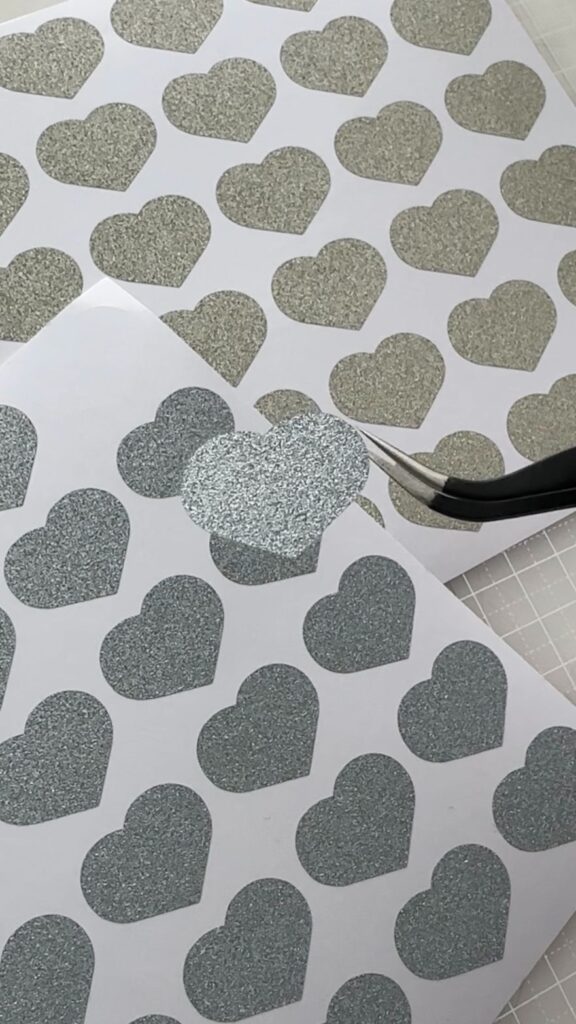 カッティングマシンでカットしたハート型の折り紙シールを剥がす様子