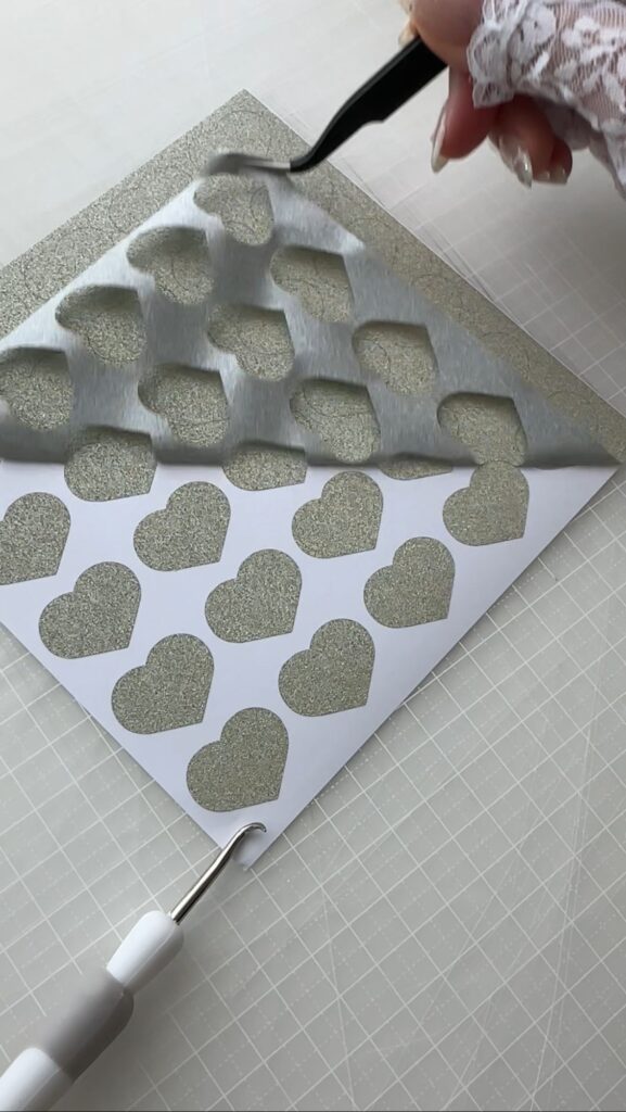カッティングマシンでカットした折り紙シールをピンセットで剥がしている様子